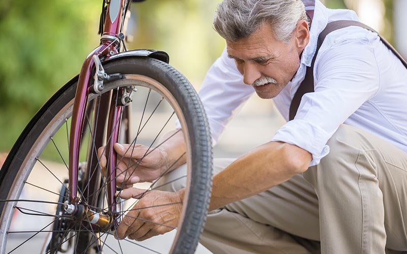 starsi pan opravuje bicykel