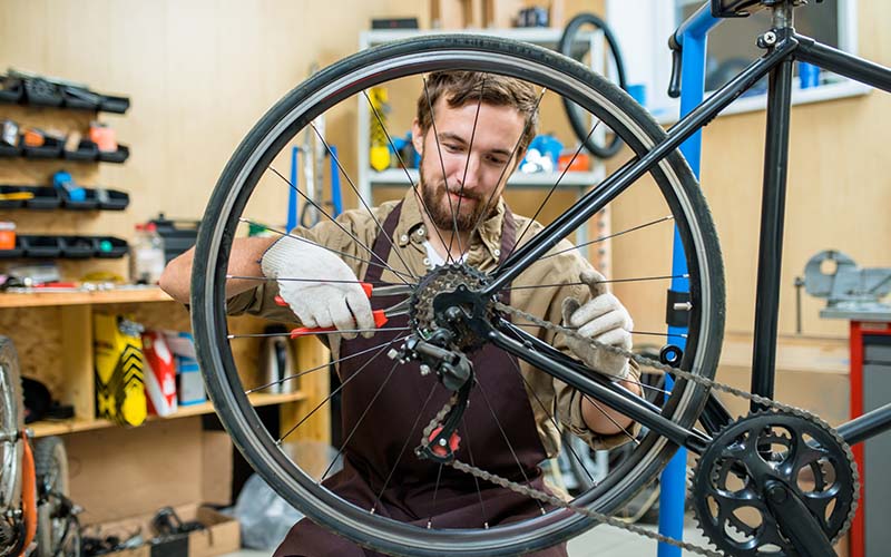 muž opravuje bicykel
