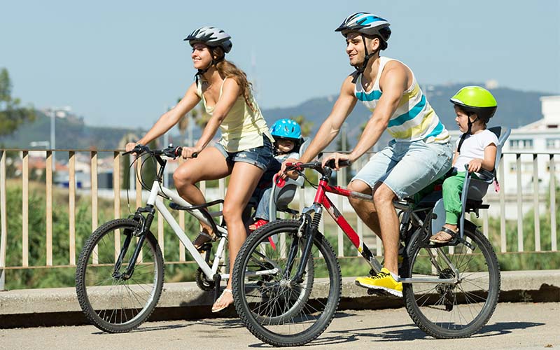 Rodičia sa vezú na bicykloch s dieťaťom vzadu